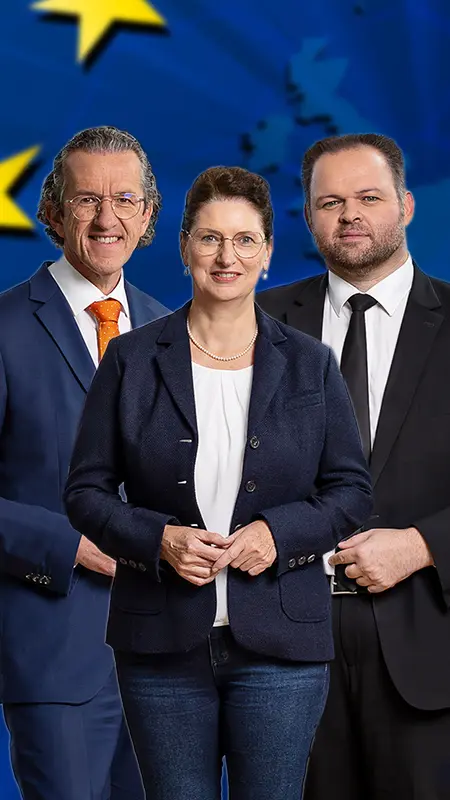 Die FREIE WÄHLER Europaabgeordneten Joachim Streit, Christine Singer und Engin Eroglu vor dem Europa-Sternenkreis auf einer blauen Europakarte.