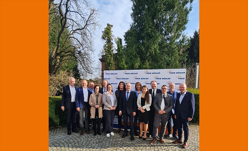 Foto der Landesvorsitzenden vor Logo-Wand.