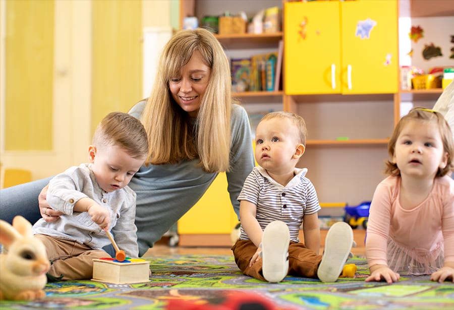 Erzieherin kümmert sich um Kinder in der Kindertagesstätte.