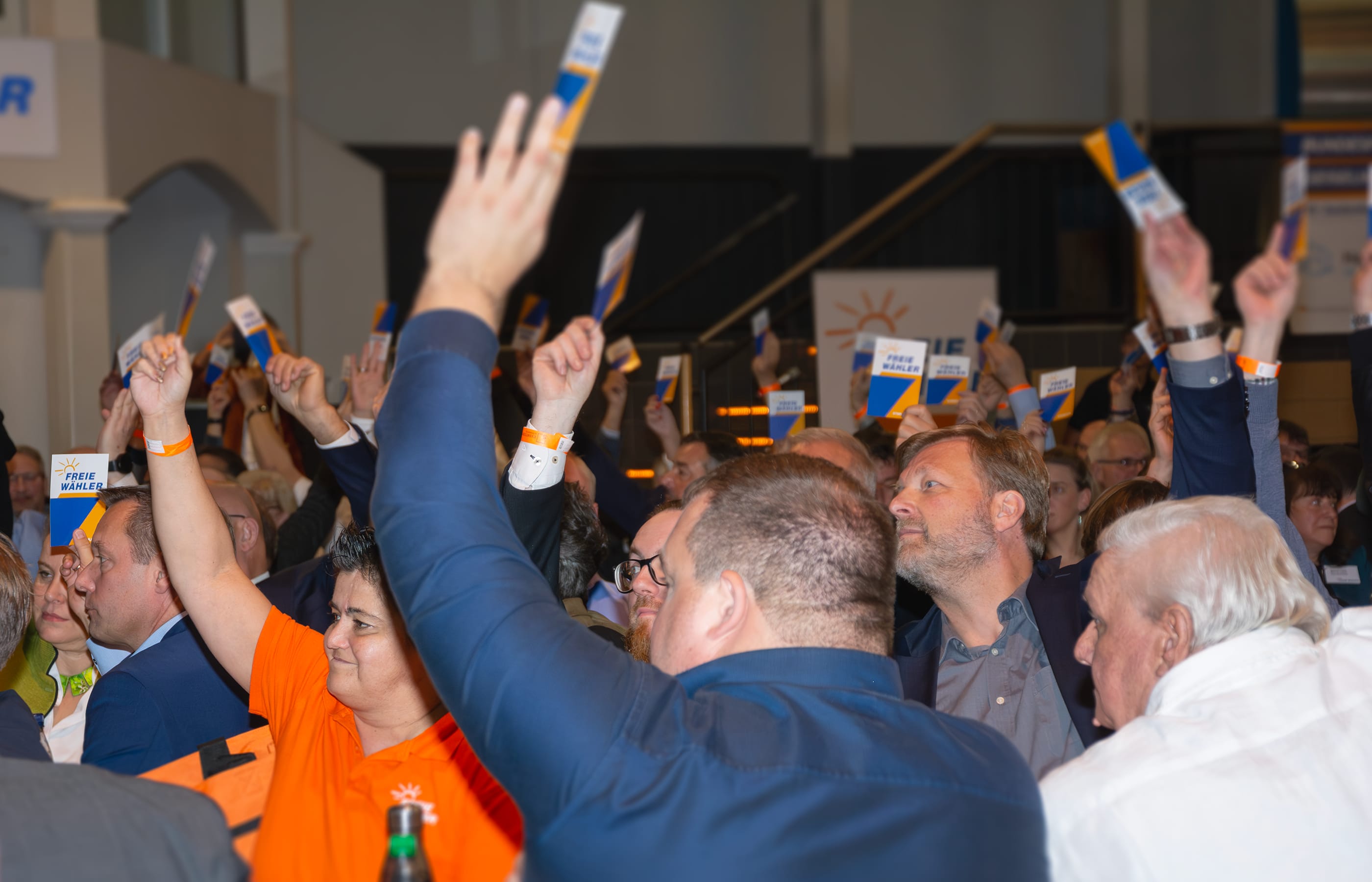 FREIE WÄHLER halten Stimmkarten hoch.